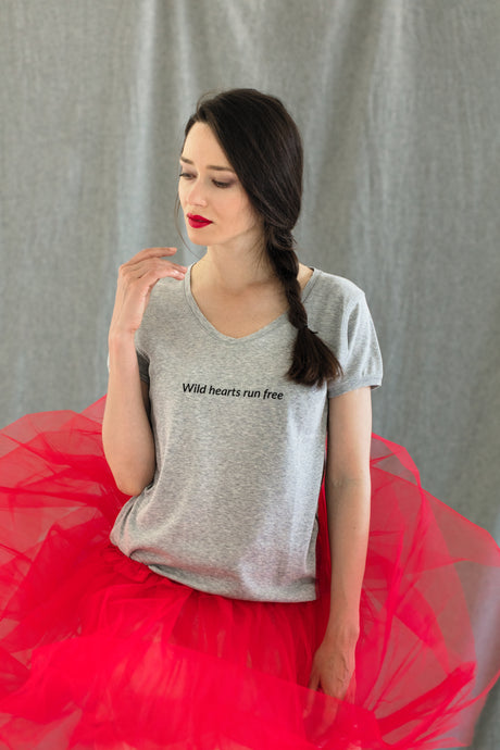 woman wears a high-quality inspirational t-shirt grey saying: Wild hearts run free